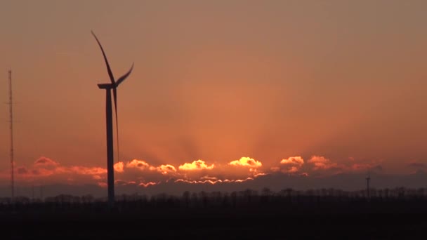 Schöner Sonnenuntergang mit Blick auf eine Windkraftanlage — Stockvideo