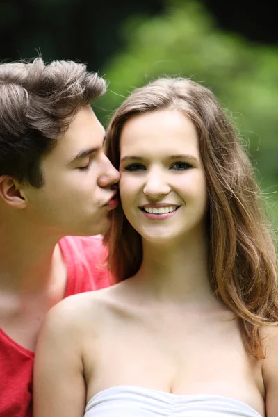 Adolescente menino beijando sua linda namorada — Fotografia de Stock