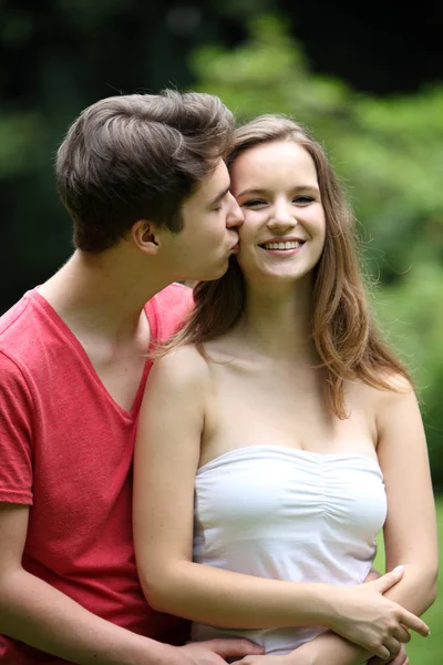 Liefdevolle jonge man zijn vriendin kussen — Stockfoto