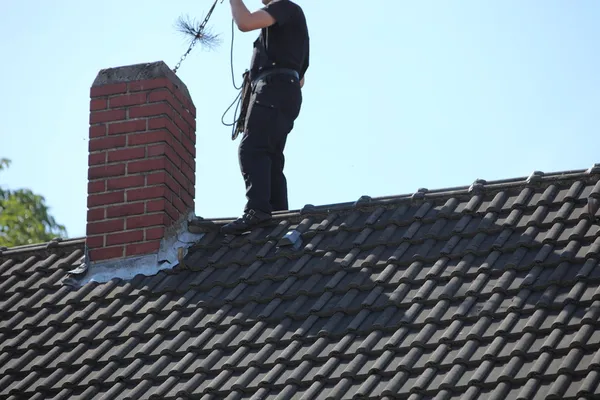 Schoorsteenveger op het werk op het dak — Stockfoto