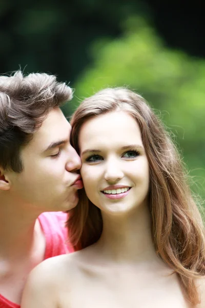 Молодой человек целует свою девушку — стоковое фото