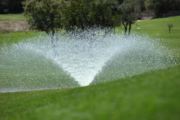 Sprinkler on a golf course — Stock Photo, Image