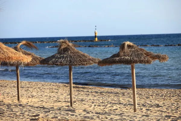 Sombrillas de paja en una playa tropical — Foto de Stock