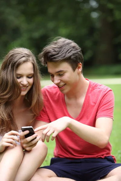 Teenage couple reading a text message — Stock Photo, Image