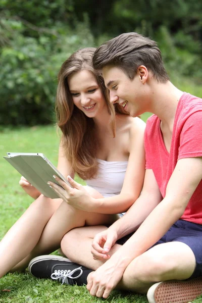 Jovens amigos adolescentes compartilhando um tablet-pc — Fotografia de Stock