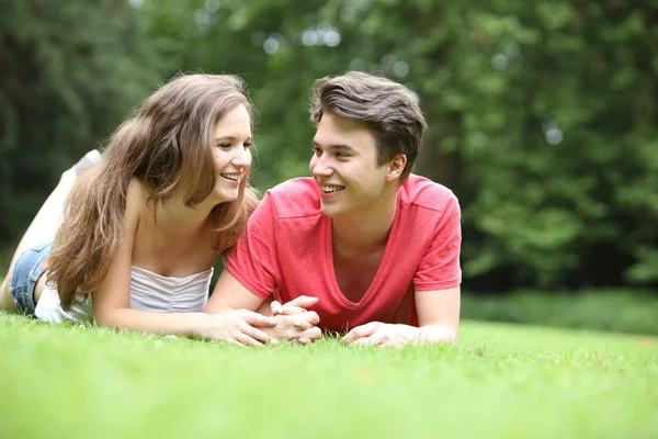 Adolescent garçon et fille couché sur l 'herbe — Photo