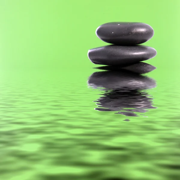 Spa massage stones in green water — Stock Photo, Image