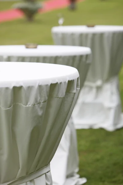 Three round tables wrapped in white table clothes — Stock Photo, Image