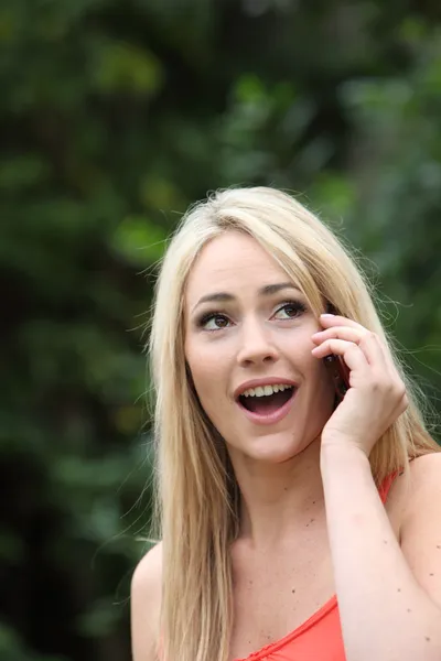 Kobieta reaguje w zachwycie do połączenia telefonu komórkowego — Zdjęcie stockowe