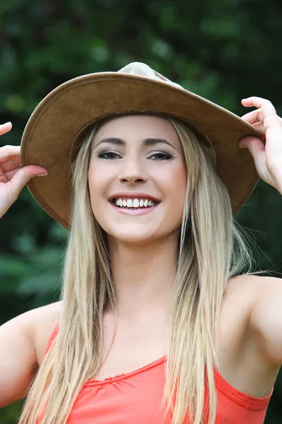 Happy young woman in a wide brimmed hat — Stock Photo, Image