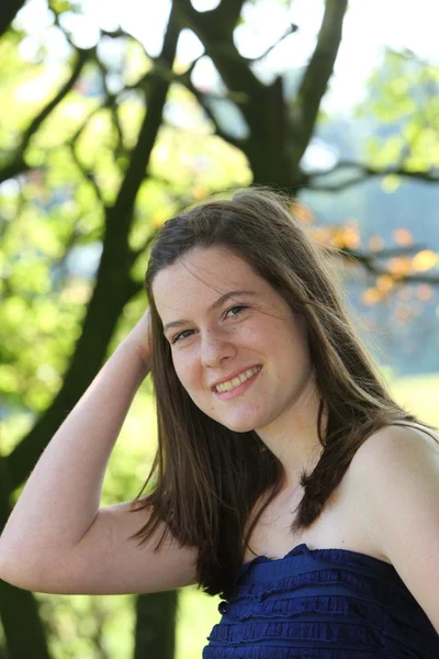 Güzel bir genç kadın şık yazlık elbise sevimli bir gülümseme — Stok fotoğraf