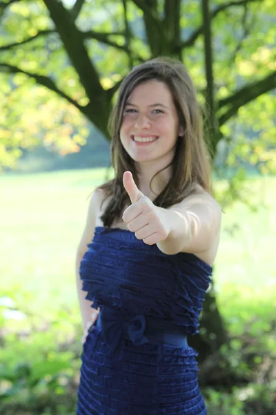 Menina adolescente bonita com cabelo longo encaracolado adorável dando um polegar para cima — Fotografia de Stock