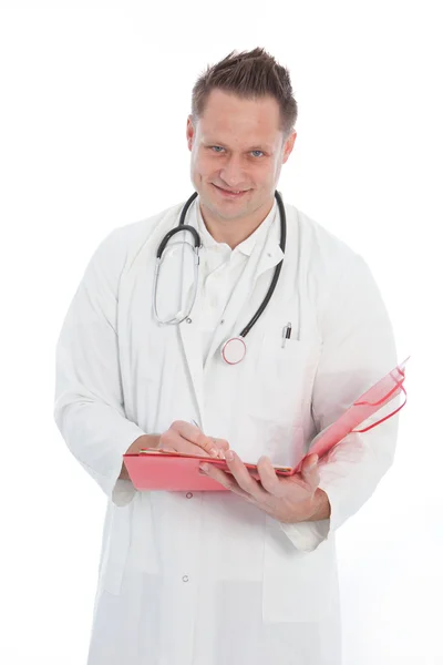 Smiling doctor writing in a patients folder Royalty Free Stock Images