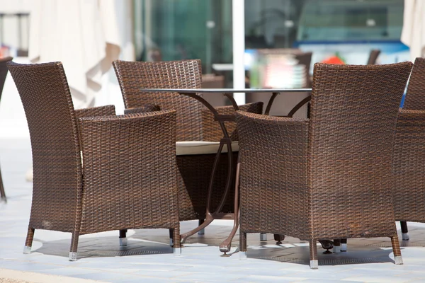 Пустые плетеные стулья вокруг стола — стоковое фото