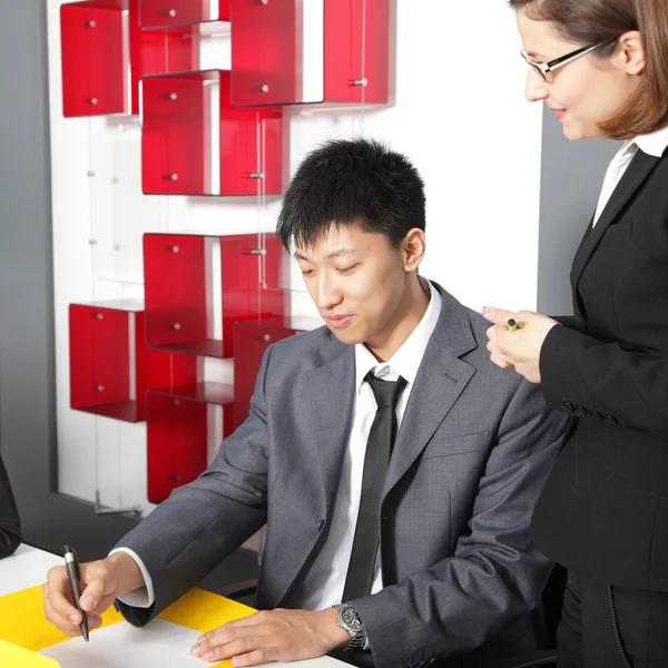 Team di lavoro multietnico in una riunione seduta in ufficio a discutere di documenti — Foto Stock