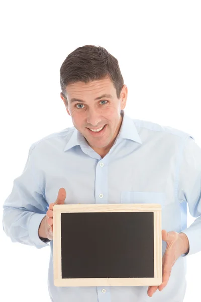 Orta yaşlı adam izleyiciye doğru boş ekran ile bir kara tahta tutan gülümseyerek — Stok fotoğraf