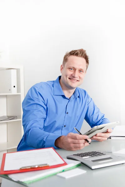 Un hombre de negocios sonriente trabajando en su escritorio —  Fotos de Stock