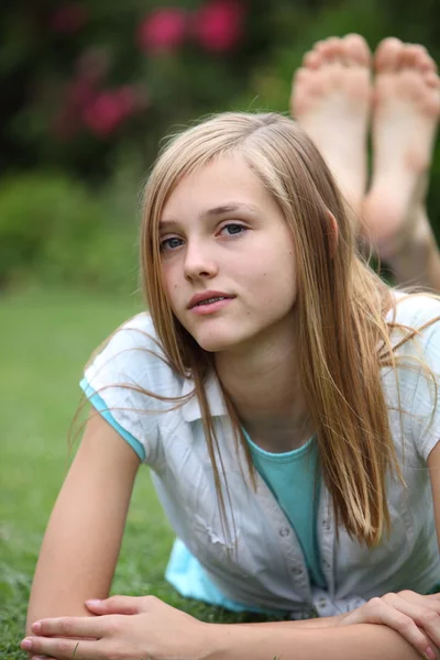 Jeune adolescent pieds nus relaxant sur l'herbe — Photo