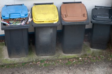 vier vuilnisbakken kleur gecodeerd voor recycling