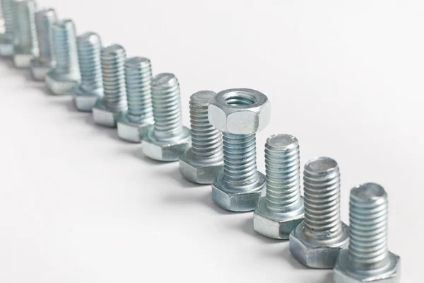 Diagonal row of bolts with a single nut — Stock Photo, Image