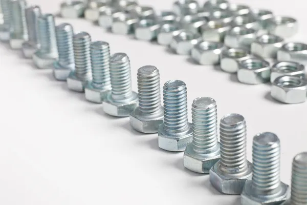 Row of silver steel bolts with a single nut — Stock Photo, Image