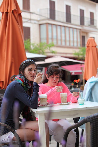 Two woman relaxing drinking coffee at a cafe
