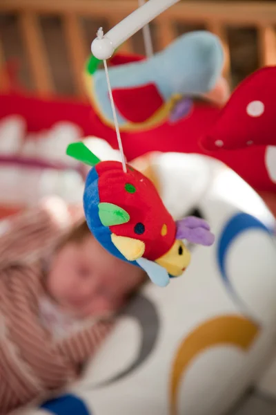 Buntes Plüschtier auf einem Babybett — Stockfoto