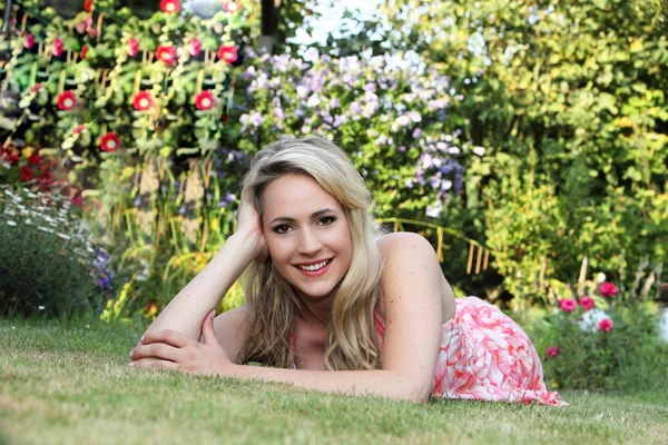 Krásná žena uvolňující na trávníku — Stock fotografie