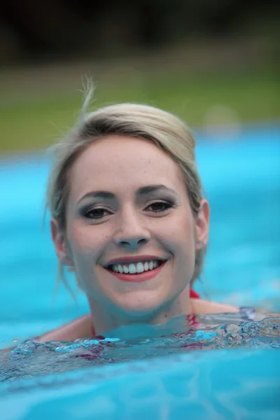 Schöne Frau schwimmt in einem Pool — Stockfoto