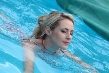 güzel kadın bir yüzme havuzunda yüzen