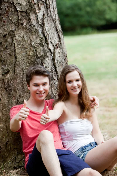 Sorrindo casal adolescente dando um polegar para cima — Fotografia de Stock