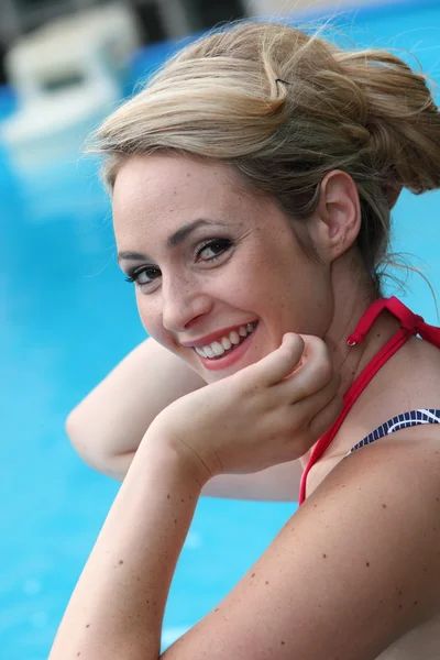 Hermosa joven rubia nadando en una piscina — Foto de Stock