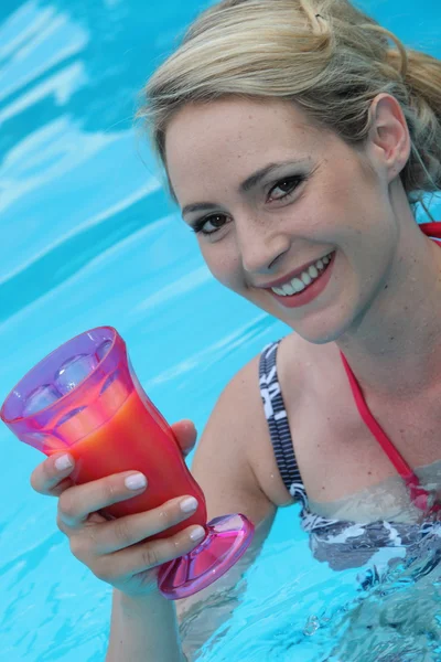 Bella giovane donna in piscina con un cocktail — Foto Stock