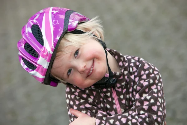 Menina adorável em um capacete de segurança rosa — Fotografia de Stock