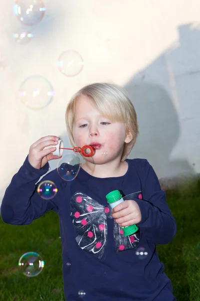 Bonita niña rubia soplando burbujas de jabón — Foto de Stock