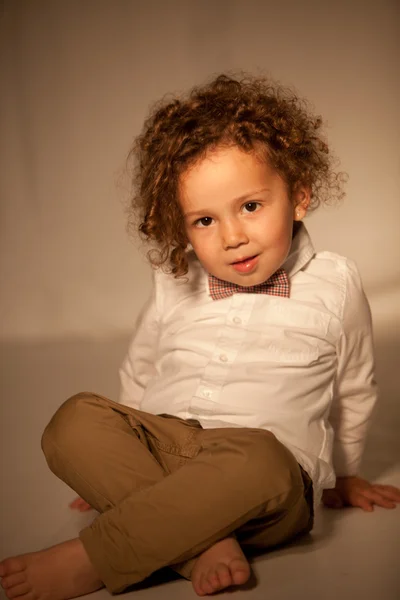 Schattige kleine jongen zitten op de vloer — Stockfoto