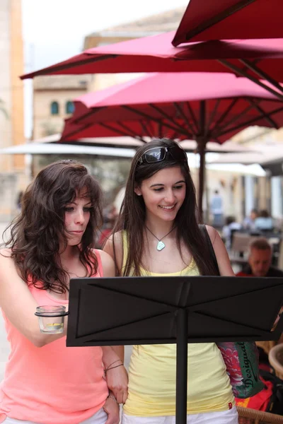 Twee vrouwen vrienden raadpleging van een menu — Stockfoto