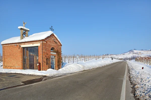 Roadside chapel and snowy vineyards. Piedmont, Italy. — Stock Photo, Image