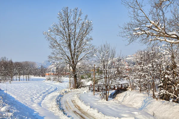 Vägen på snöiga fältet. Piemonte, Italien. — Stockfoto