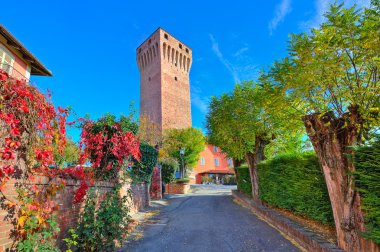 Alley and red tall medieval tower in Piedmont, Italy. clipart