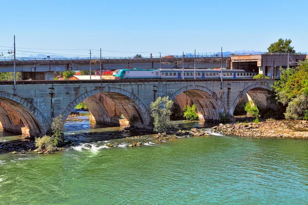 Zug auf der Brücke über den Fluss im Piemont, Italien. — Stockfoto