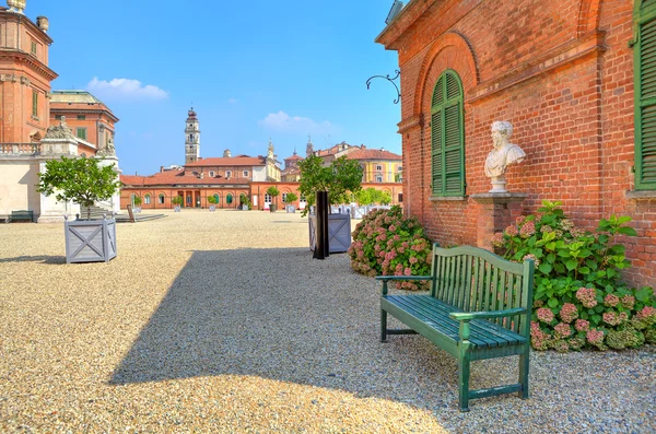 Bench on gravel next to brick house in Piedmont, Italy. — Stock Photo, Image