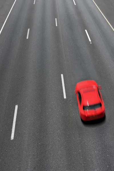 Rode auto beweegt snel op snelweg. — Stockfoto