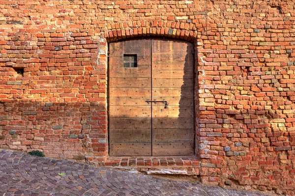 Τοίχο από τούβλα με ξύλινη πόρτα. — Φωτογραφία Αρχείου