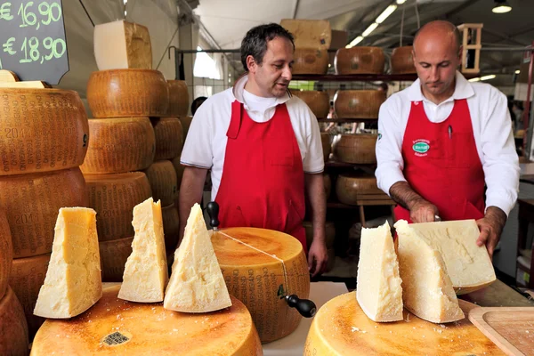 Kaasmakers en wielen van parmezaan in Italië. — Stockfoto