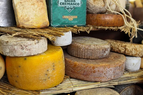 Kerekek érett sajt az állvány. — Stock Fotó