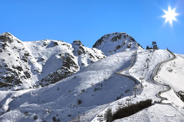 Bergen bedekt met sneeuw onder de blauwe hemel. — Stockfoto