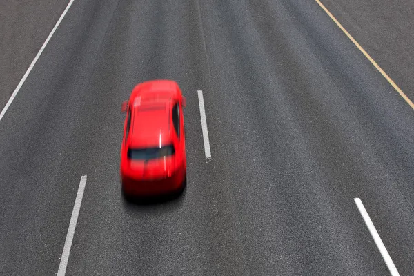 Rode auto beweegt snel op snelweg. — Stockfoto