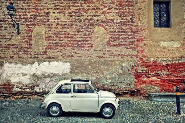 Viejo coche pequeño contra la pared de ladrillo . — Foto de Stock