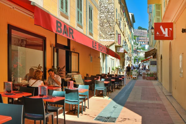 Stradă îngustă cu restaurante în Menton . — Fotografie, imagine de stoc